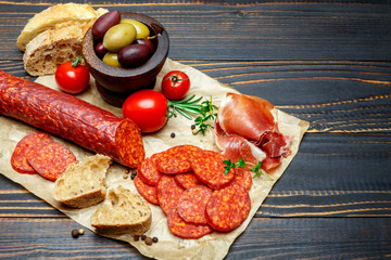 Dried organic salami sausage on wooden background