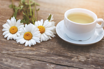 Fototapeta na wymiar Cup of tea and chamomile on table
