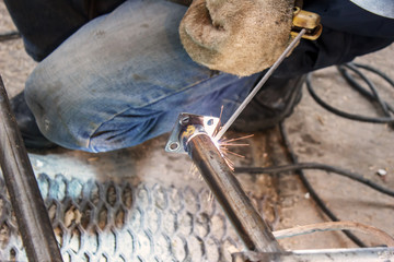Worker welding the steel part by manual