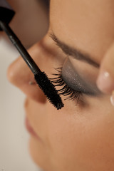 Closeup of makeup artist applying mascara
