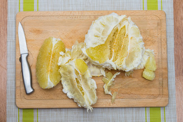 Purified pomelo lying on a wooden board