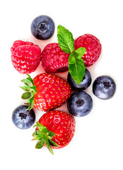 Fresh berries isolated on white background, top view. Strawberry, Raspberry, Blueberry and Mint leaf, flat lay.