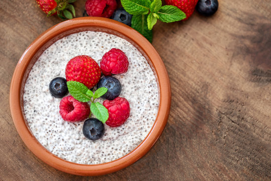 Chia. Superfoods breakfast with Chia seed pudding and  berries in a bowl over wooden rustic background. Health concept, omega 3 product. Top view, flat lay.