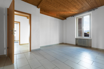Empty room with wooden ceiling and grey tiles