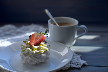 A traditional Pavlov dessert with strawberry and coffee. French cuisine. Dark background