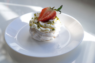 A traditional Pavlov dessert with strawberry and coffee. French cuisine. White background