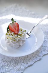 A traditional Pavlov dessert with strawberry and coffee. French cuisine. White background