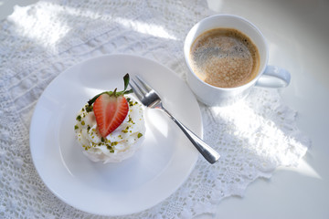 A traditional Pavlov dessert with strawberry and coffee. French cuisine. White background