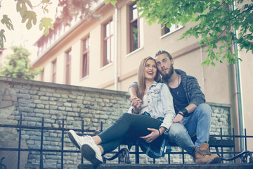 Young couple in the park. Couple sitting on the bench.