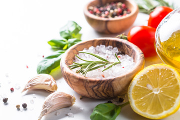 Spices, herbs and olive oil over white stone table.