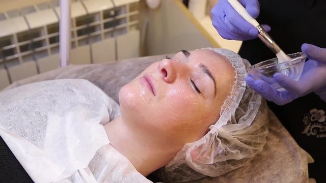 Applying cosmetic gel on the face patient.