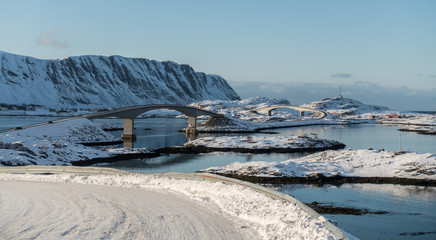 with snow and ice covered road, small islands conected with a brigde, lofoten, norway 
