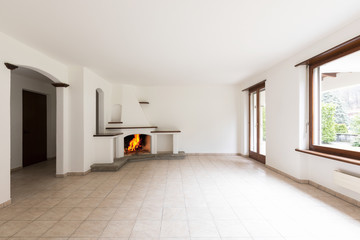 Room with large windows and lit fireplace