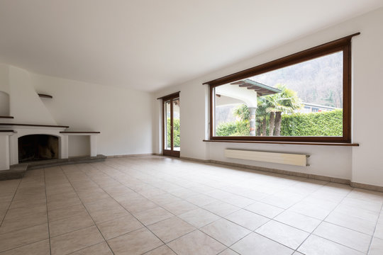 Room with large windows and lit fireplace. Beauty living room.