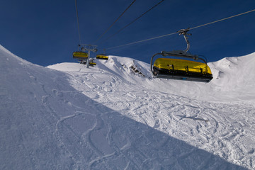 Yellow chair lifts against the beautiful mountains.