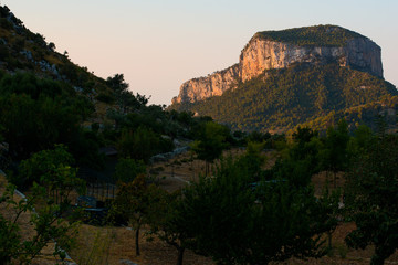 Fototapeta na wymiar Rocky hill lit by sunrise rays in Mallorca, morning light