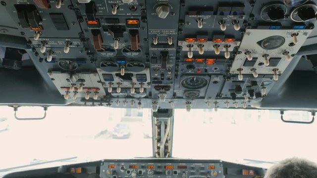 Pilot pushes buttons on panel of airplane