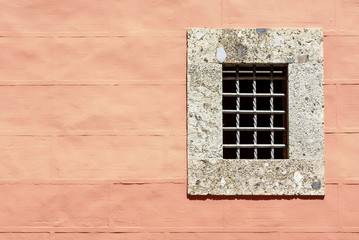 small window on rose wall