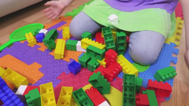 Little girl near colorful toy bricks