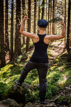 Young Strong Grit Woman With Muscles In The Forest. Unisex Concept. Full Body Portrait From Behind.