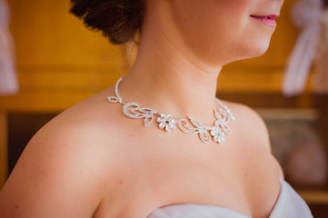 Detail of a silver necklace on a bride during the wedding day