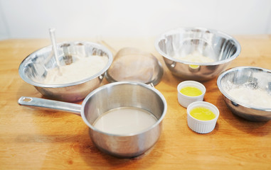 cooking food and baking concept - bowls with flour and egg whites at bakery kitchen
