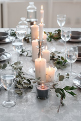 Wedding or festive table setting. Plates, wine glasses, candles and cutlery