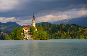 Bled lake and pilgrimage church in sunlit with dark background