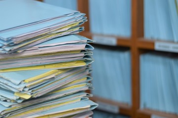 Paper documents of unfinished stacked on office desk archive.