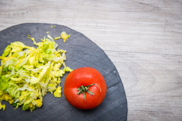 Tomato and lettuce on a grey wooden table