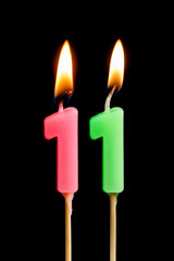 Burning candles in the form of 11 eleven figures (numbers, dates) for cake isolated on black...