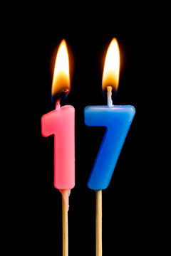 Burning candles in the form of 17 seventeen figures (numbers, dates) for cake isolated on black background. The concept of celebrating a birthday, anniversary, important date, holiday, table setting