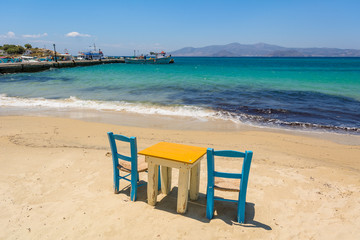 Table with chairs with view on sea bay on Agia Anna beach, Naxos Island. Greece.