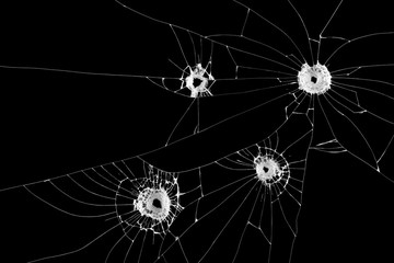 Four bullet holes on window isolated on black background.