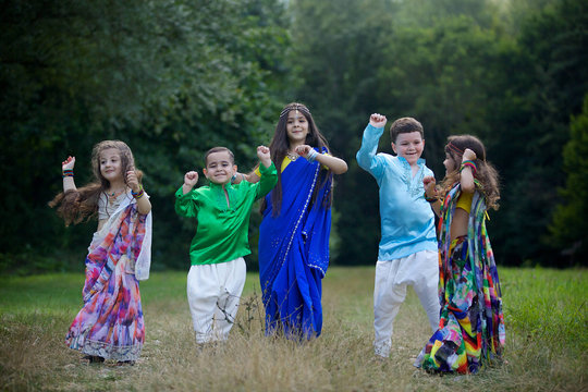 A lot of small children, boys and girls, dressed in the clothing culture of India.