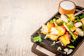 Vegan diet food, Grilled cheese and vegetables kebab, indian style Paneer Tikka, with white sauce and lime, on light concrete background, copy space