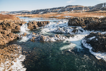 majestic icelandic landscape with hills and rapid river at sunny day, Hraunfossar, iceland