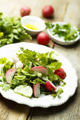Healthy spring salad with herbs, cucumber and fresh radish