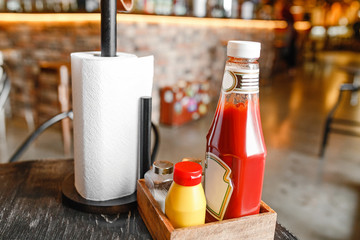 Ketchup and mustard in jars on the table in a burger snack bar or fastfood restaurant