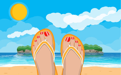 Fototapeta premium Womens feet in flip flops. Landscape of beach