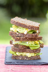 Sandwich with avocado and poached egg - healthy breakfast concept