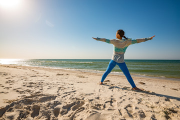 Woman practice yoga on the seashore