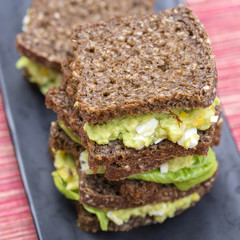 Sandwich with avocado and poached egg - healthy breakfast concept
