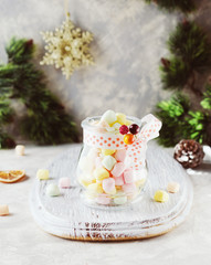 Obraz na płótnie Canvas jar with marshmallows for Christmas and New Year on a wooden white table, selective focus