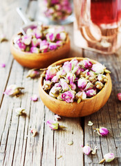 small dry buds of roses, tea, karkade, in wooden bowls, selective focus