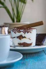 Homemade Italian dessert tiramisu and coffee on the table by the window