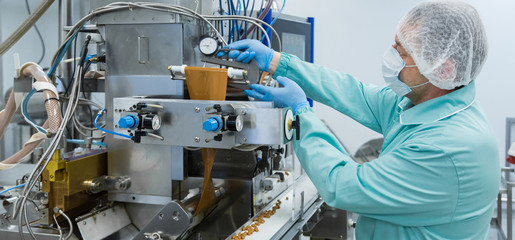 Pharmacy industry factory man worker in protective clothing in sterile working conditions