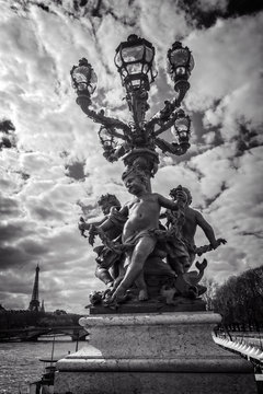 Fototapeta Street lantern from year 1900 on bridge Alexandre III, the river Seine and the Eiffel tower, Paris, France, black and white photography