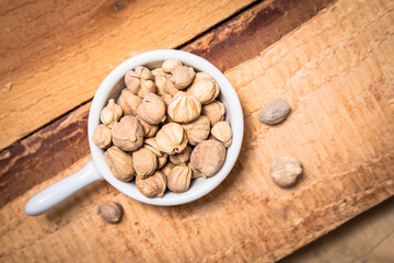 Exotic spices concept organic Thai Cardamom pods in white cup on wood background with copy space