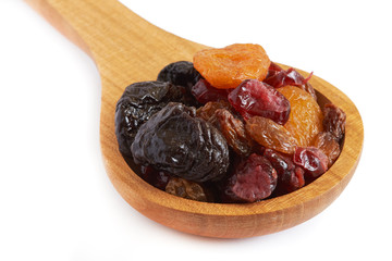 Mix of dried fruits (prunes, raisins, apricots and cranberries) in wooden spoon isolated on white background